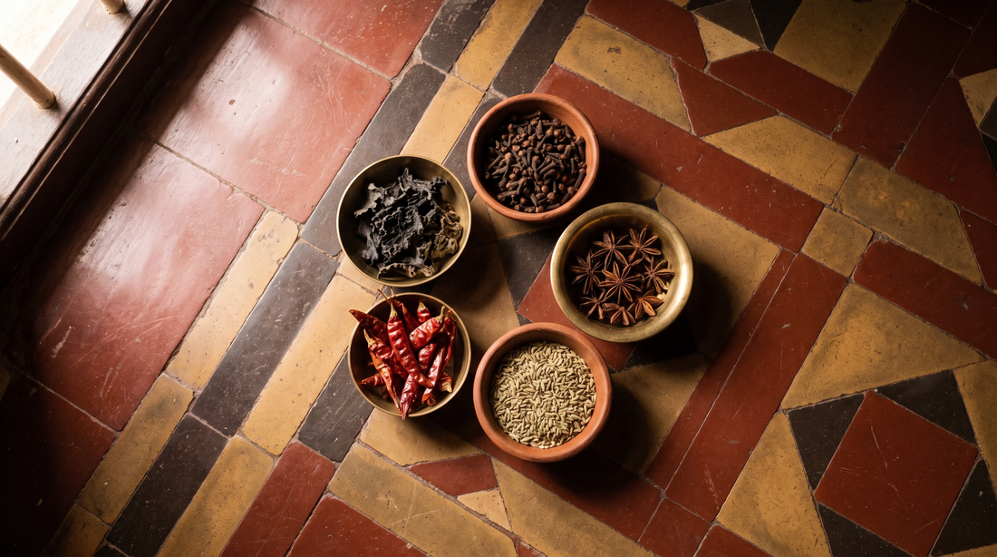 Chettinad spices in small bowls: kalpasi, marathi mokku, star anise, red chillies, fennel