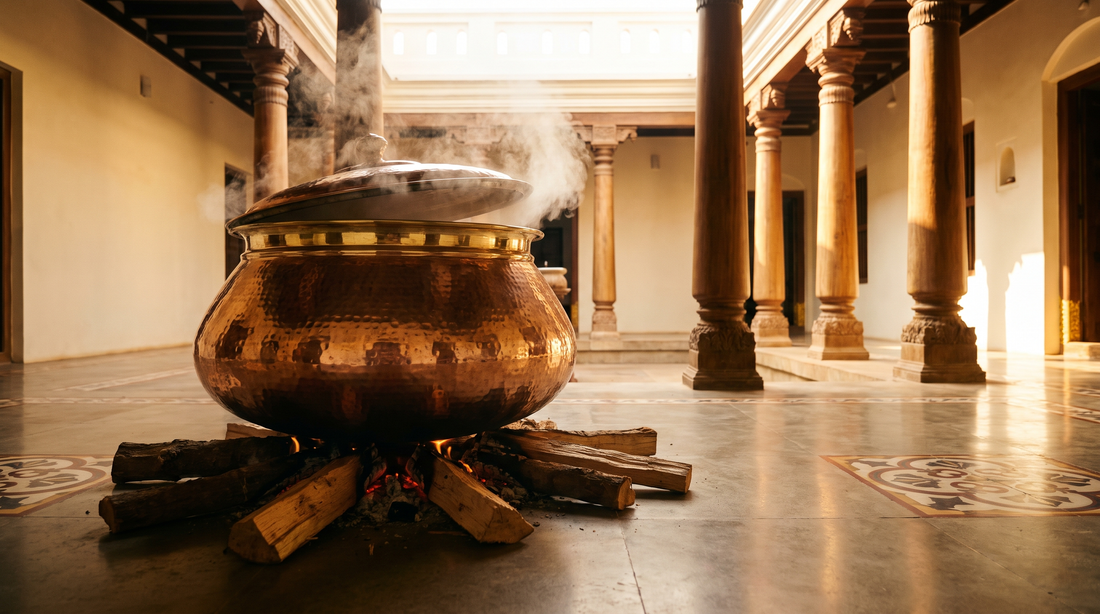 Large copper biryani degh on a wood fire in the stone courtyard of a heritage mansion