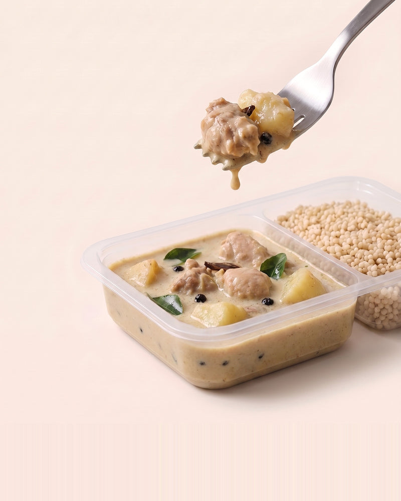 Kerala Chicken Ishtu, a forkful lifted from the open tray, coconut stew beside pearl millet