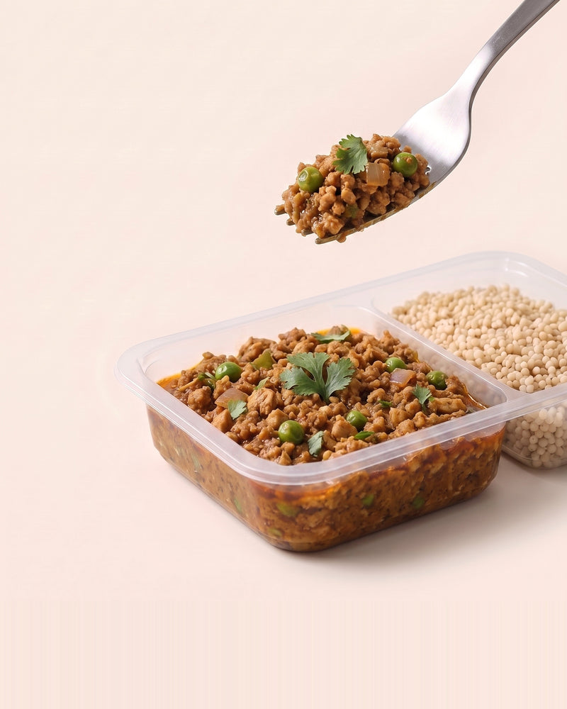 Chicken Keema Breakfast Bowl, a forkful lifted from the open tray, keema beside pearl millet
