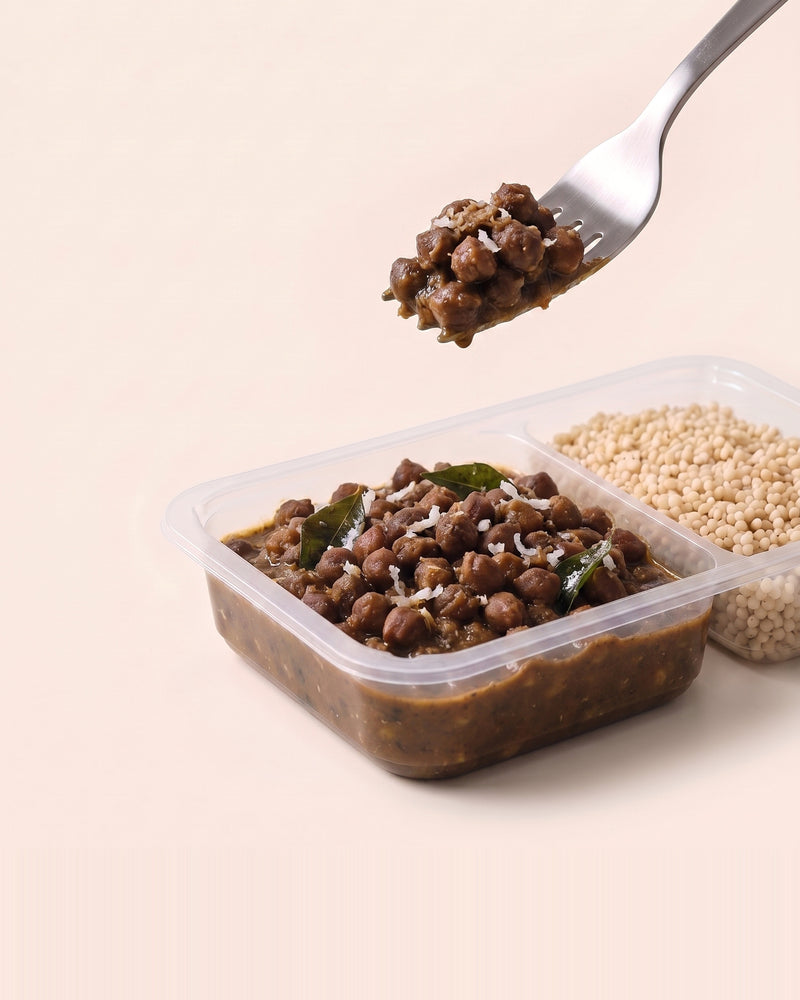 Kadalai Black Chana Bowl, a forkful lifted from the open tray, black chana beside pearl millet