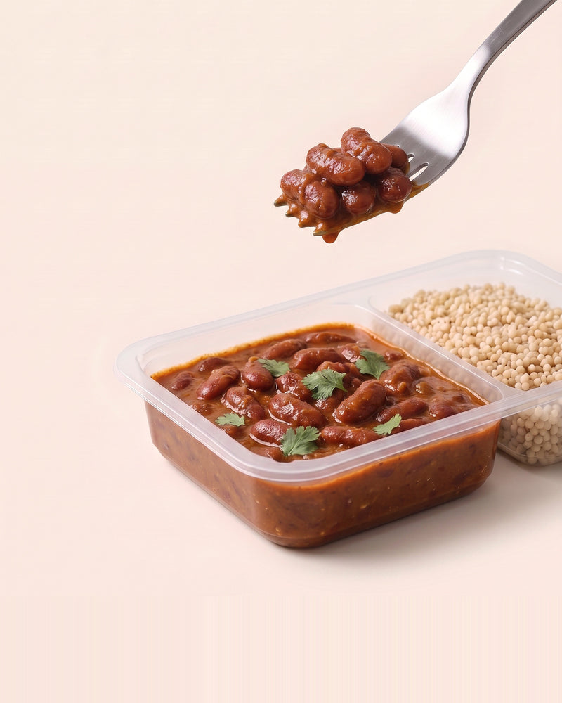 Rajma Protein Bowl, a forkful lifted from the open tray, rajma beside pearl millet