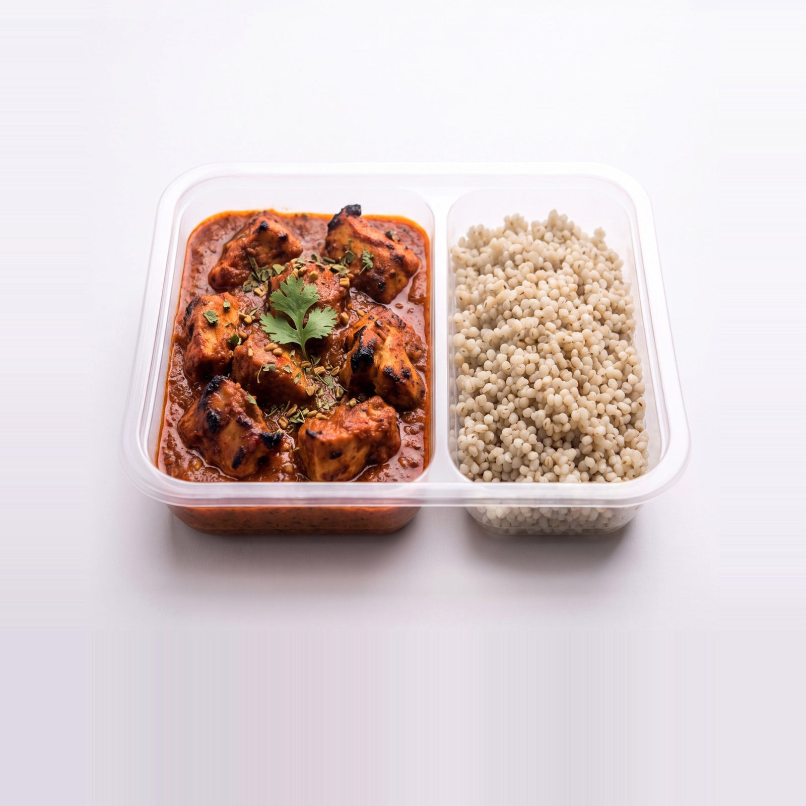 Chicken Tikka Masala Bowl, the open tray with tomato masala gravy beside pearl millet