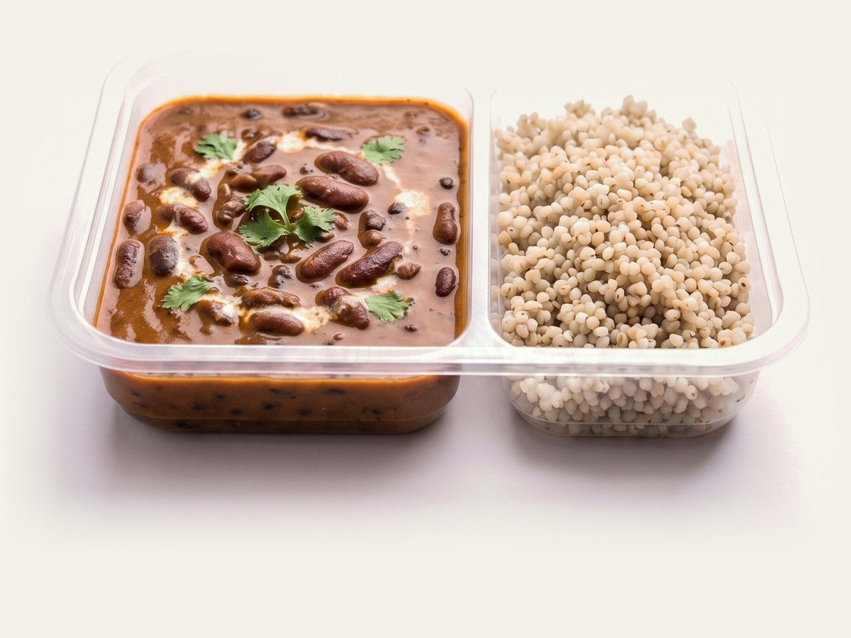 A retort tray of a Fuel vegetarian rajma curry beside its rice compartment, on a plain cream studio background.